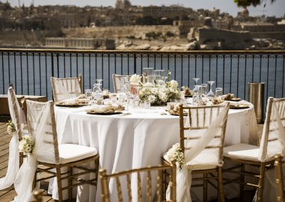 Outdoor wedding reception table overlooking Valletta harbour in Malta